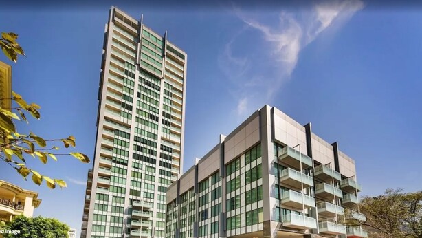 A modern high-rise building with multiple balconies and a clear sky. - Seasons Botanic Gardens (Melbourne)