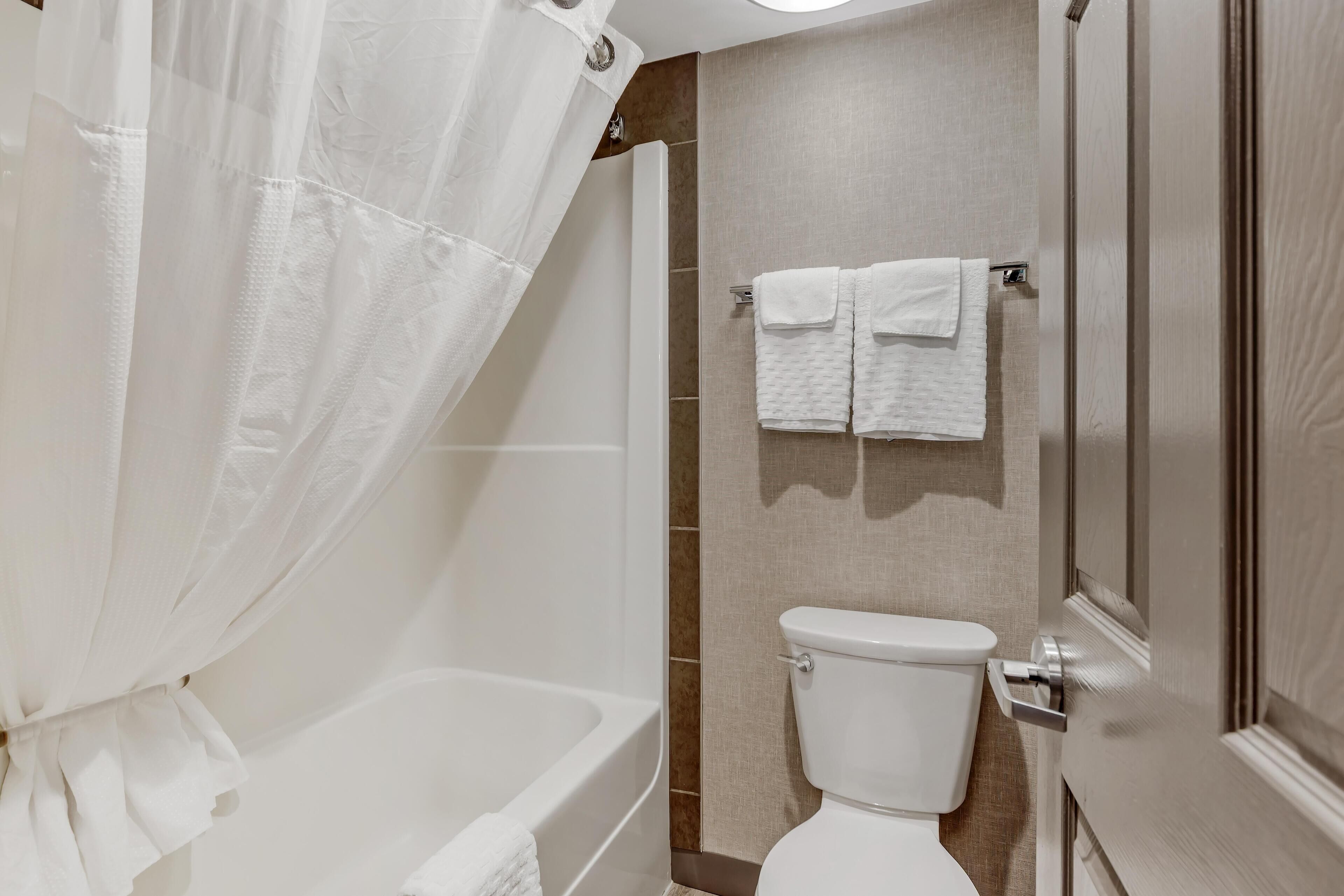 Ein Badezimmer mit einer Badewanne, Toilette und einer Duschvorhang.