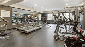 Un centre de remise en forme équipé de tapis de course, de vélos elliptiques et d'appareils de musculation.