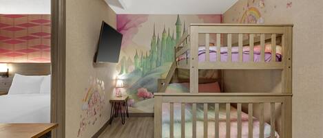 A child's bedroom with bunk beds, a TV mounted on the wall, and a mural of a castle.