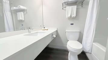 Un baño moderno con lavamanos doble, inodoro, toallero y espejo.