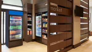 A grocery store interior with refrigerated beverage dispensers and shelves stocked with snacks and beverages. - Residence Inn by Marriott London Ontario (London)