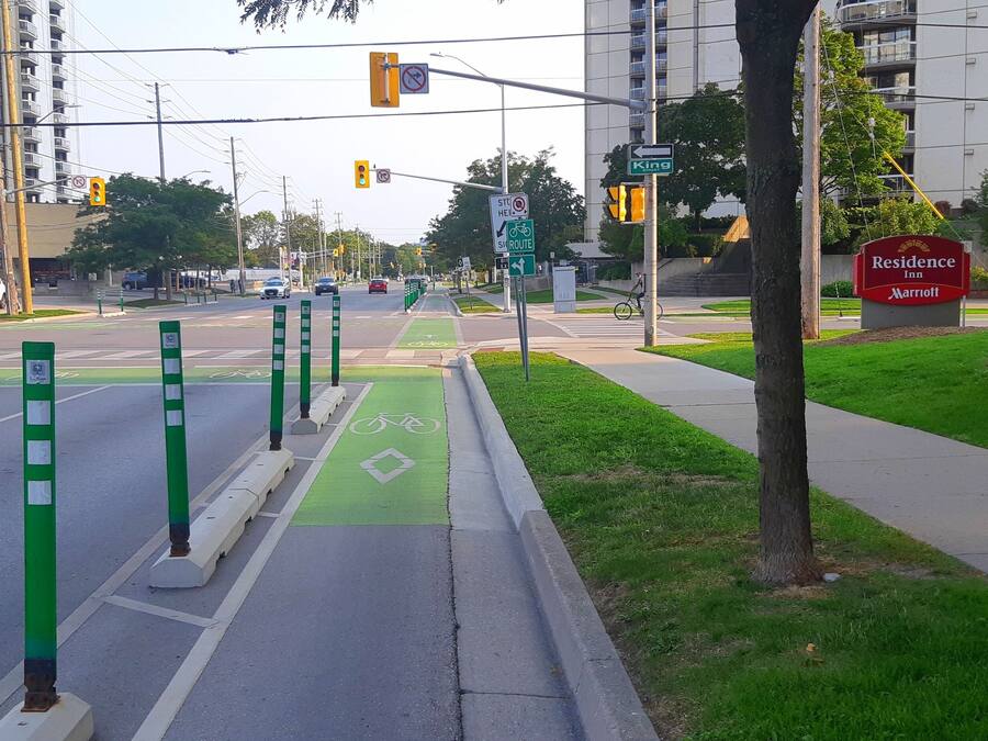 A street view with a bike lane, traffic lights, and a sign for King Residence Inn Marriott.