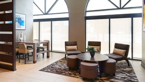 A modern hotel lobby with a dining area, comfortable seating, and large windows. - Residence Inn by Marriott London Ontario (London)