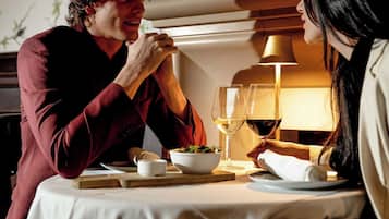 A dining table with a white tablecloth, two wine glasses, and a candle holder.