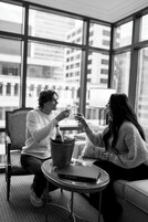 Two people sitting at a table with a bottle of champagne and a book titled "CHANEL".