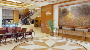 A grand lobby with a large chandelier, a staircase, and a large floral painting on the wall. - Richmonde Hotel Ortigas (Pasig)