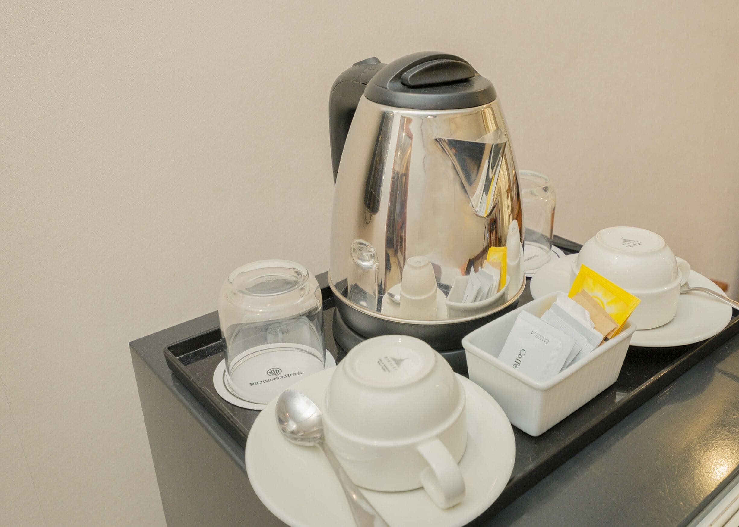Ein Frühstückswagen mit einer Kaffeemaschine, Tassen und einer Aufbewahrungsbox für Würzmittel.
