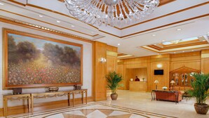 A spacious lobby with a large floral painting, a reception desk, and a decorative chandelier. - Richmonde Hotel Ortigas (Pasig)