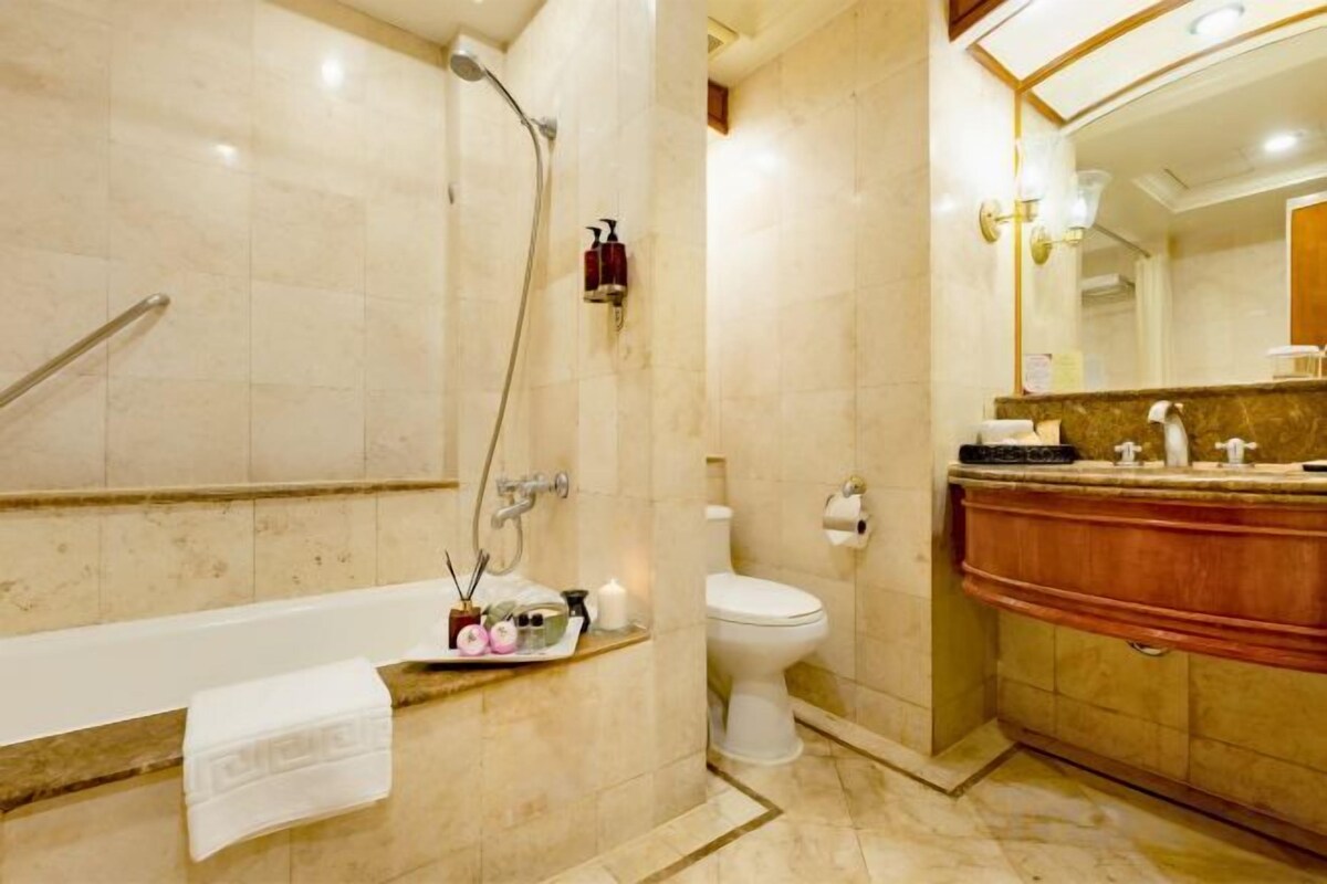 A bathroom with a bathtub, toilet, and vanity.