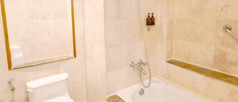 A bathroom with a toilet, a bathtub, and a shower.