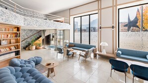 Una sala moderna con un sofá azul, una mesa de centro y una estantería.