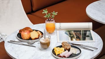 A breakfast setting with a table, a sofa, and a magazine.