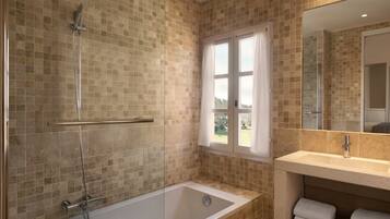 Un baño con ducha de vidrio, bañera y lavabo con espejo.