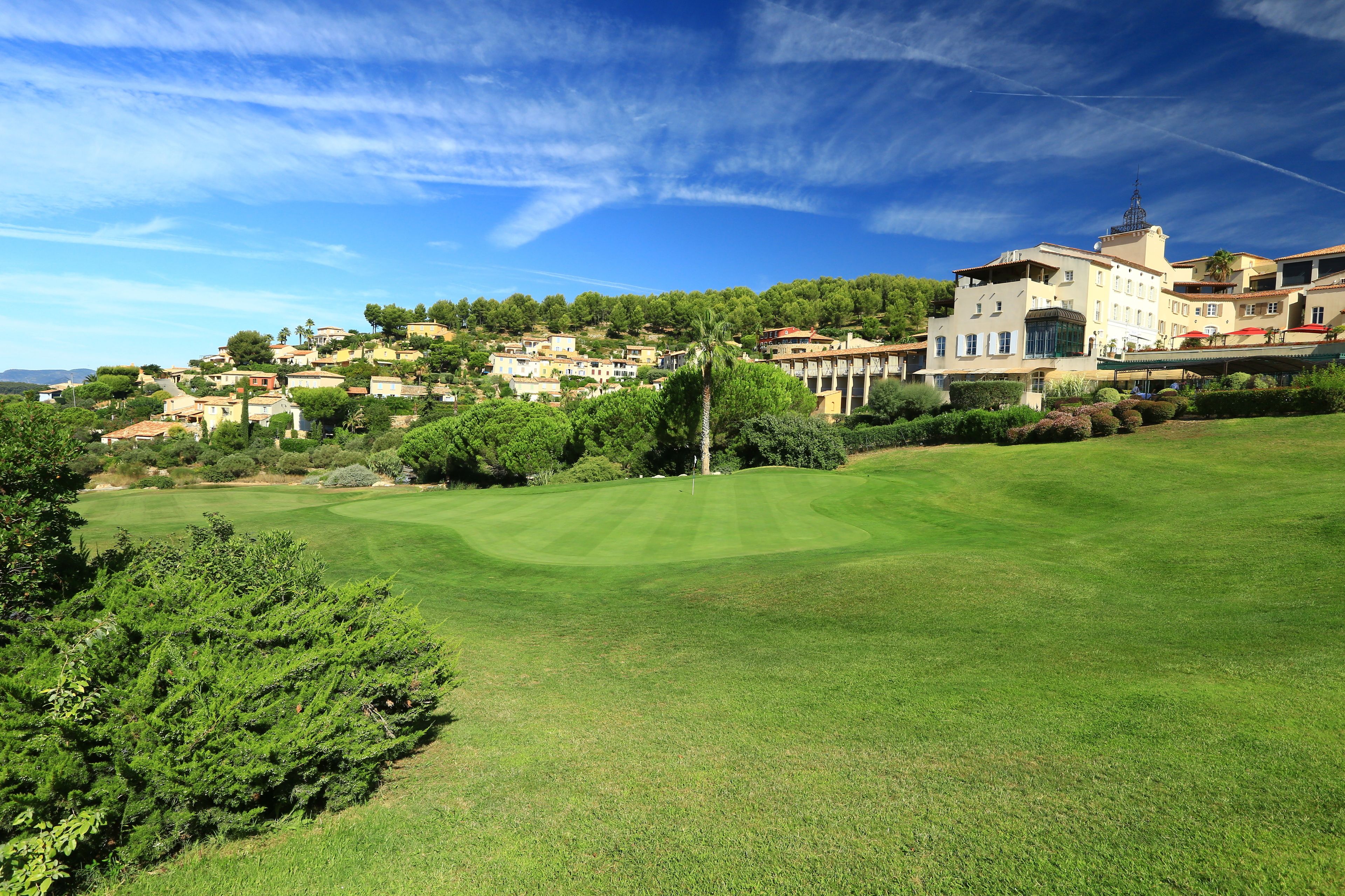A golf course with a large building in the background.