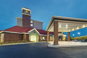 A hotel with a red roof, a prominent sign, and a covered parking area. - La Quinta Inn & Suites by Wyndham Oklahoma City - NW Expwy (Oklahoma City)