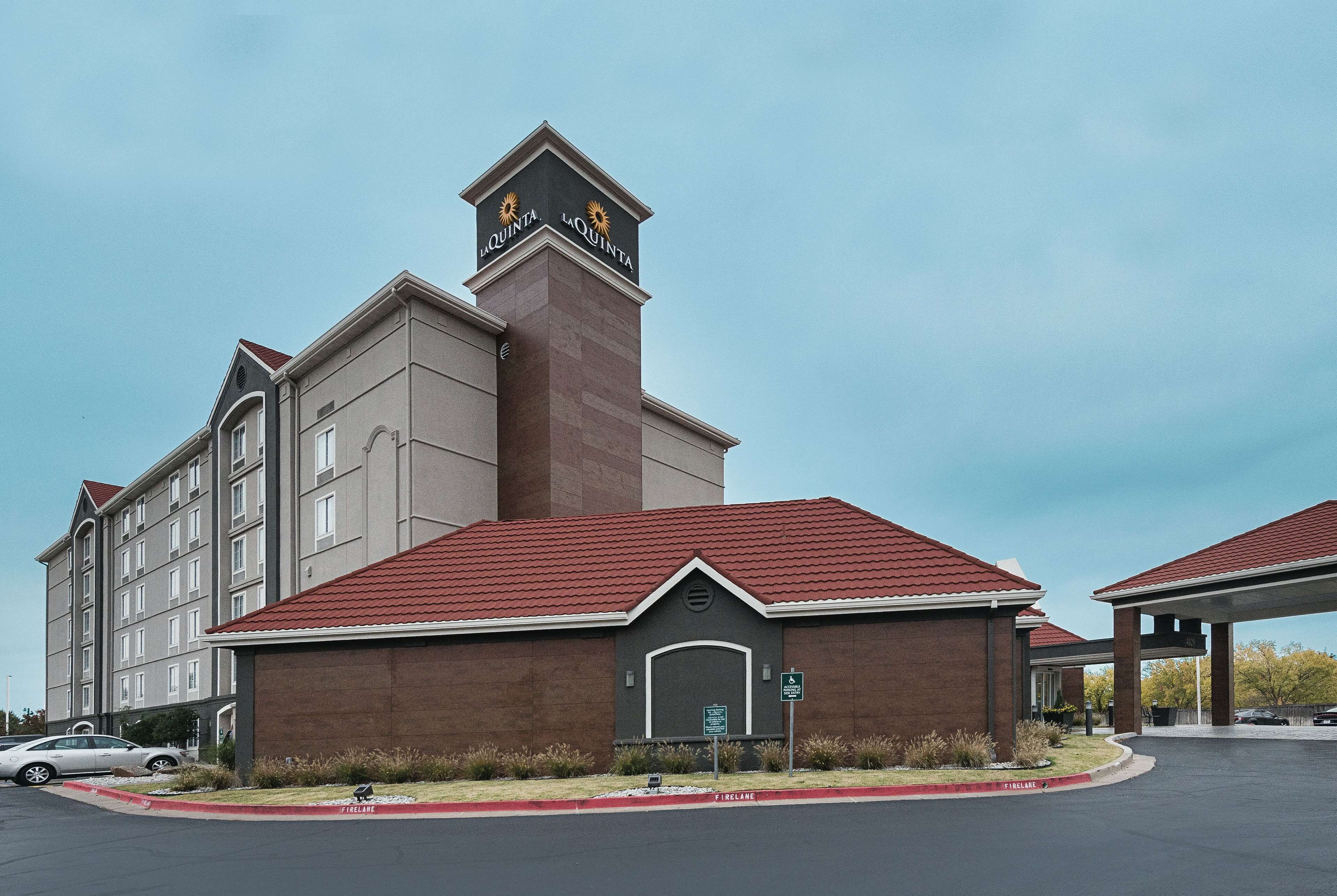A hotel with a prominent sign reading "La Quinta" and a parking area in front.