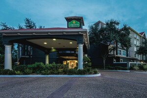 L’entrée d’un hôtel, dotée d’un espace abrité, de colonnes et d’une enseigne indiquant qu’il s’agit du La Quinta Inn & Suites.