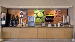 A hotel reception area with a coffee station, a refrigerator, and a fruit display. - La Quinta by Wyndham Haywood Mall-Near Greenville Downtown (Greenville)