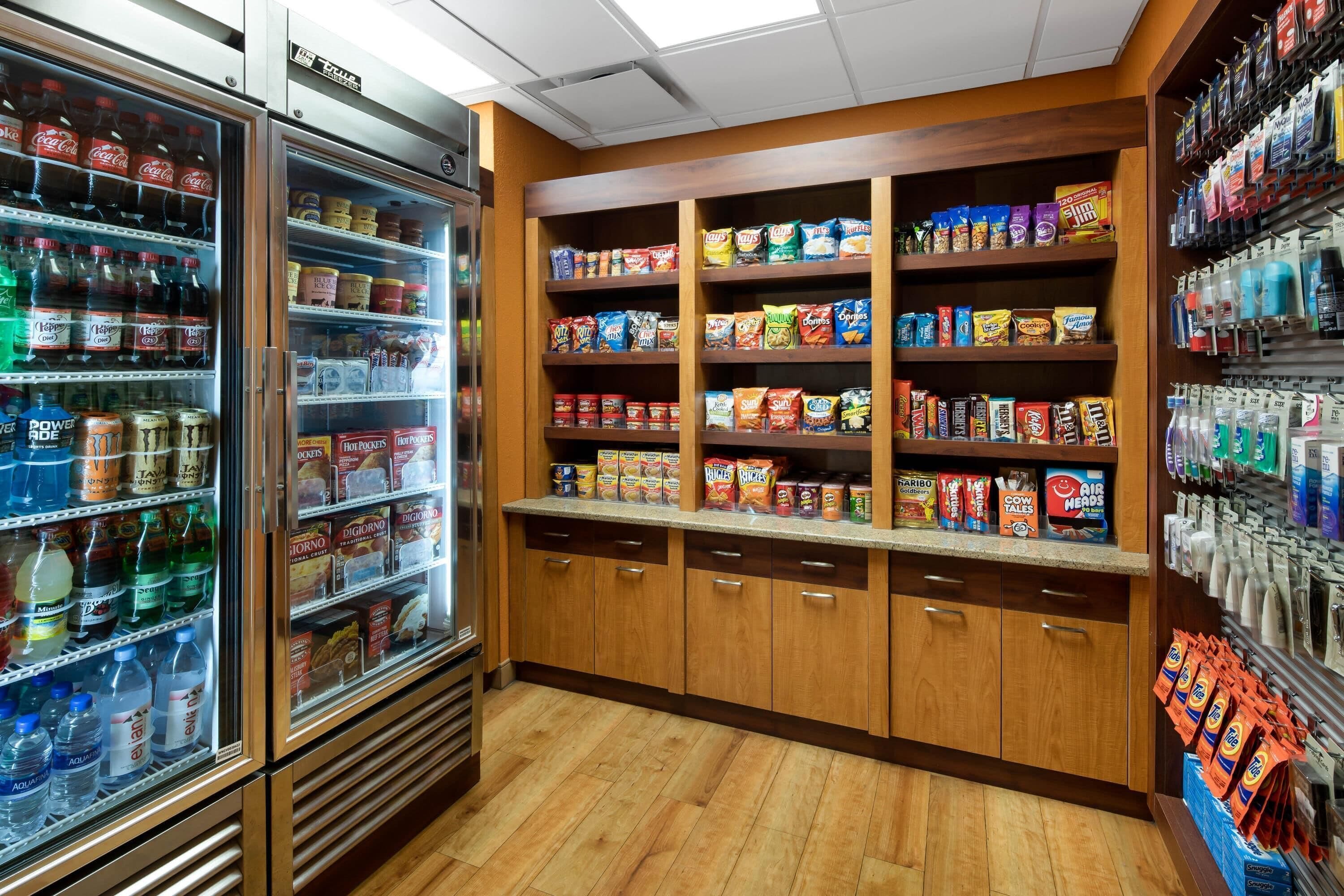A grocery store with refrigerated beverages, snack aisles, and packaged goods.