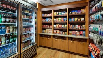 A grocery store with refrigerated beverages, snack aisles, and packaged goods.
