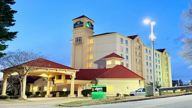 A hotel with a prominent tower, a covered entrance, and a well-lit facade. - La Quinta by Wyndham Haywood Mall-Near Greenville Downtown (Greenville)