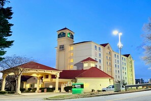 A hotel with a prominent tower, a covered entrance, and a well-lit facade. - La Quinta by Wyndham Haywood Mall-Near Greenville Downtown (Greenville)
