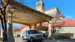 A white van parked under a covered area with a building in the background. - La Quinta by Wyndham Haywood Mall-Near Greenville Downtown (Greenville)