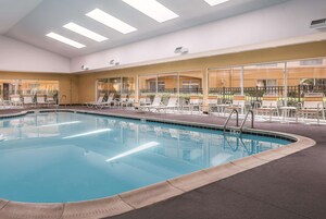 Una piscina al aire libre de temporada, sillones reclinables de piscina