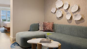 Una sala de estar moderna con un sofá gris, una mesa de centro redonda y decoración en la pared.