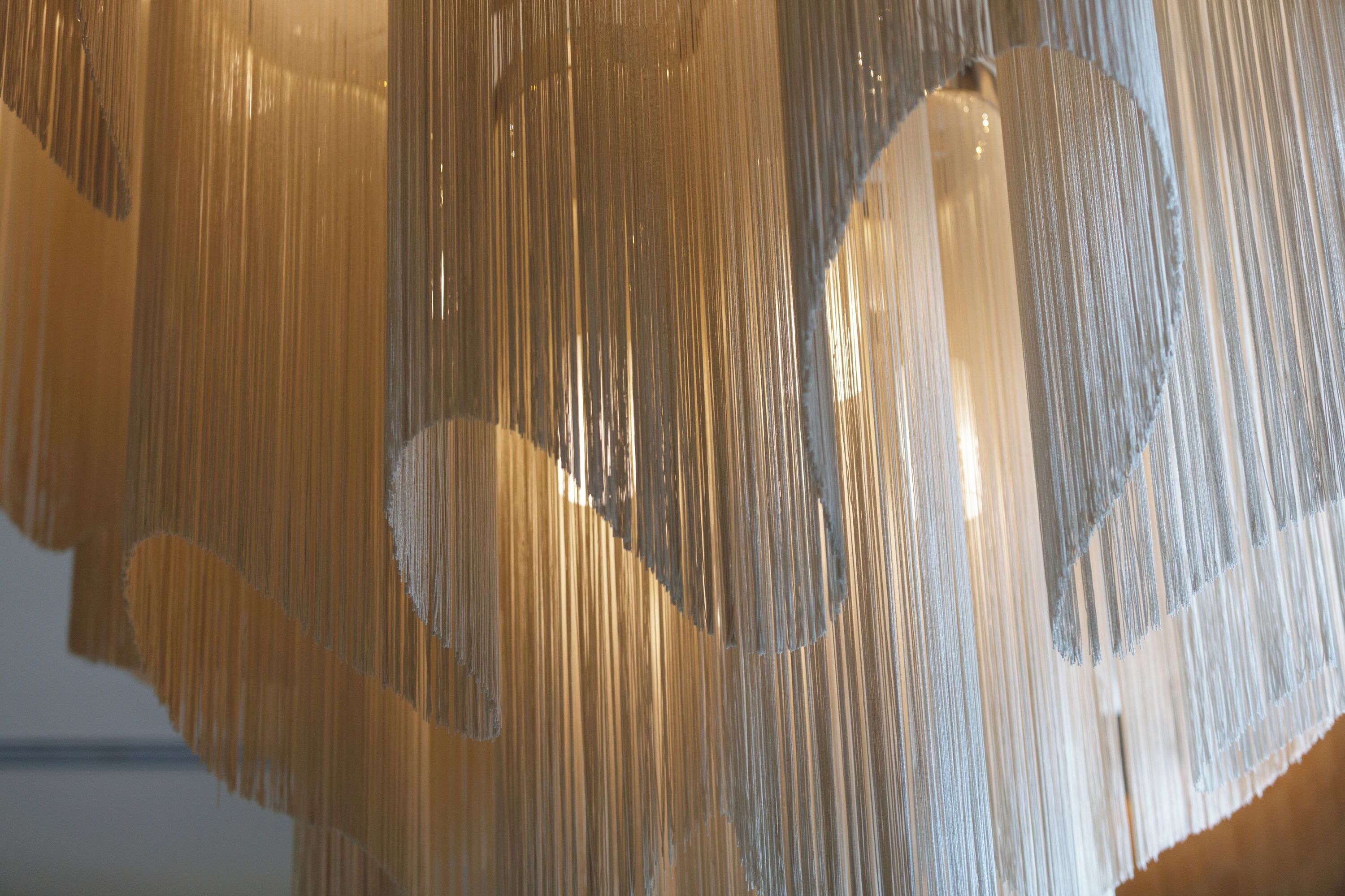 A close-up of a textured, vertical fabric installation, likely part of a building's interior design.