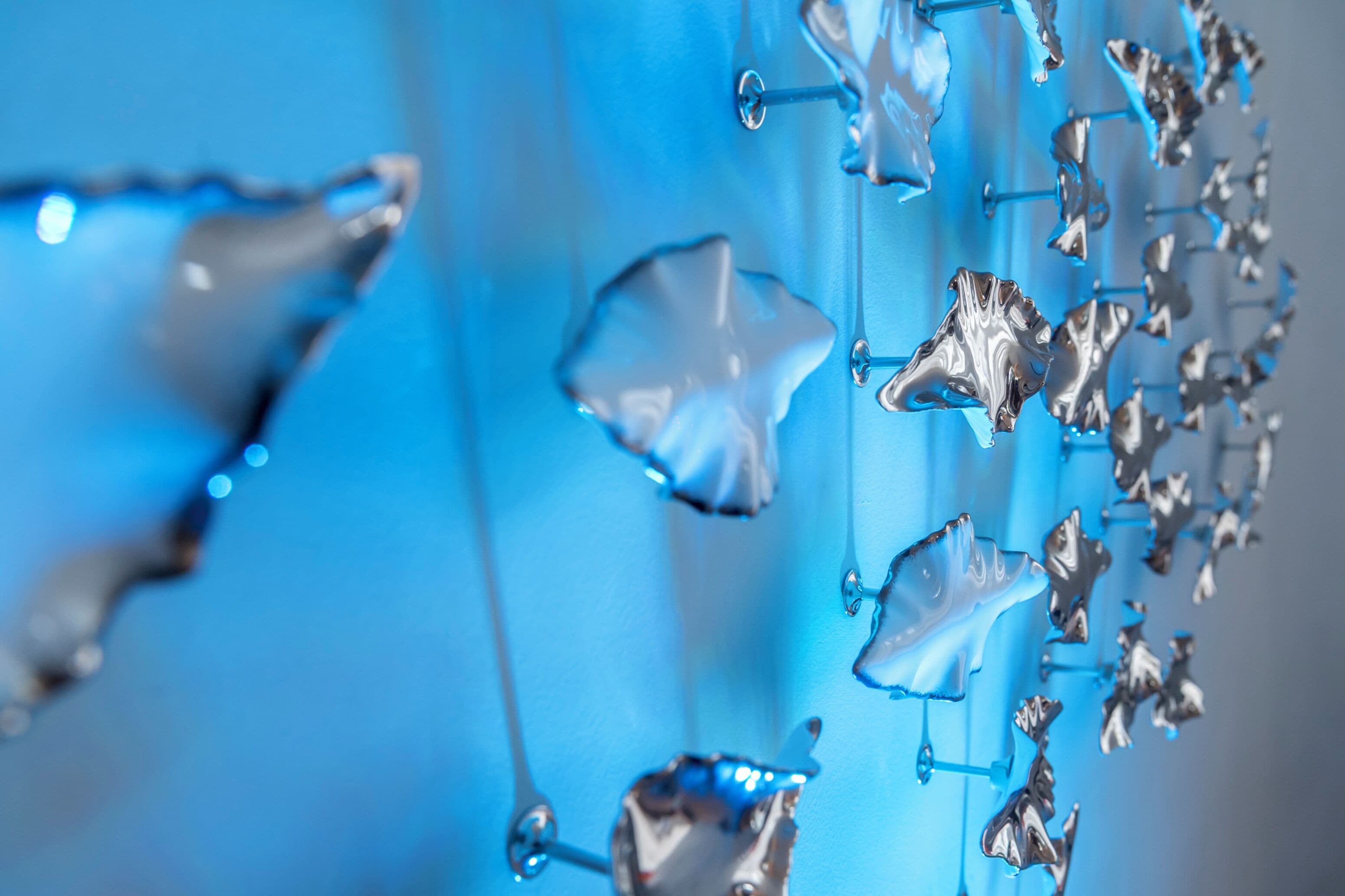 Un gros plan de décorations métalliques en forme d’étoile sur un fond bleu.