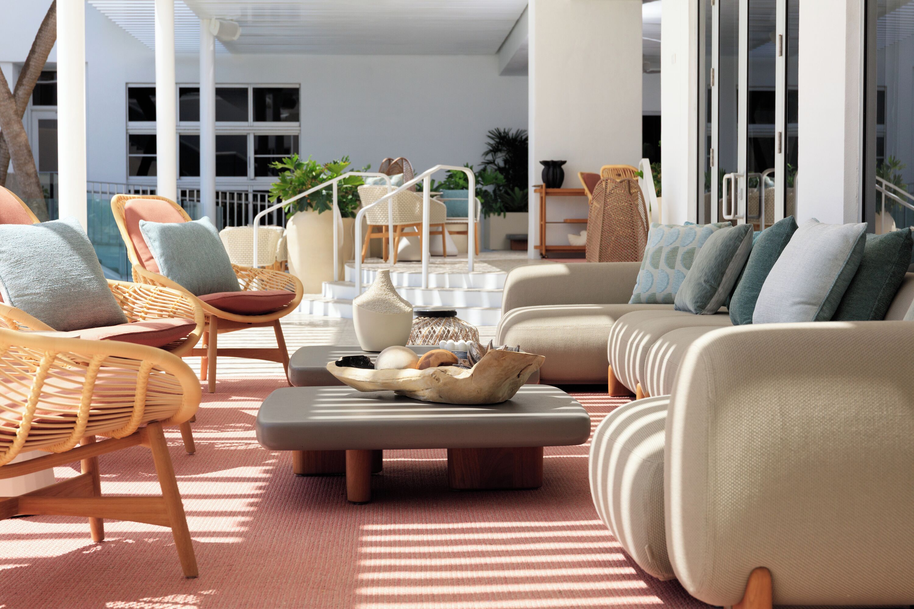 A modern outdoor seating area with wicker chairs, a sofa, and a coffee table.
