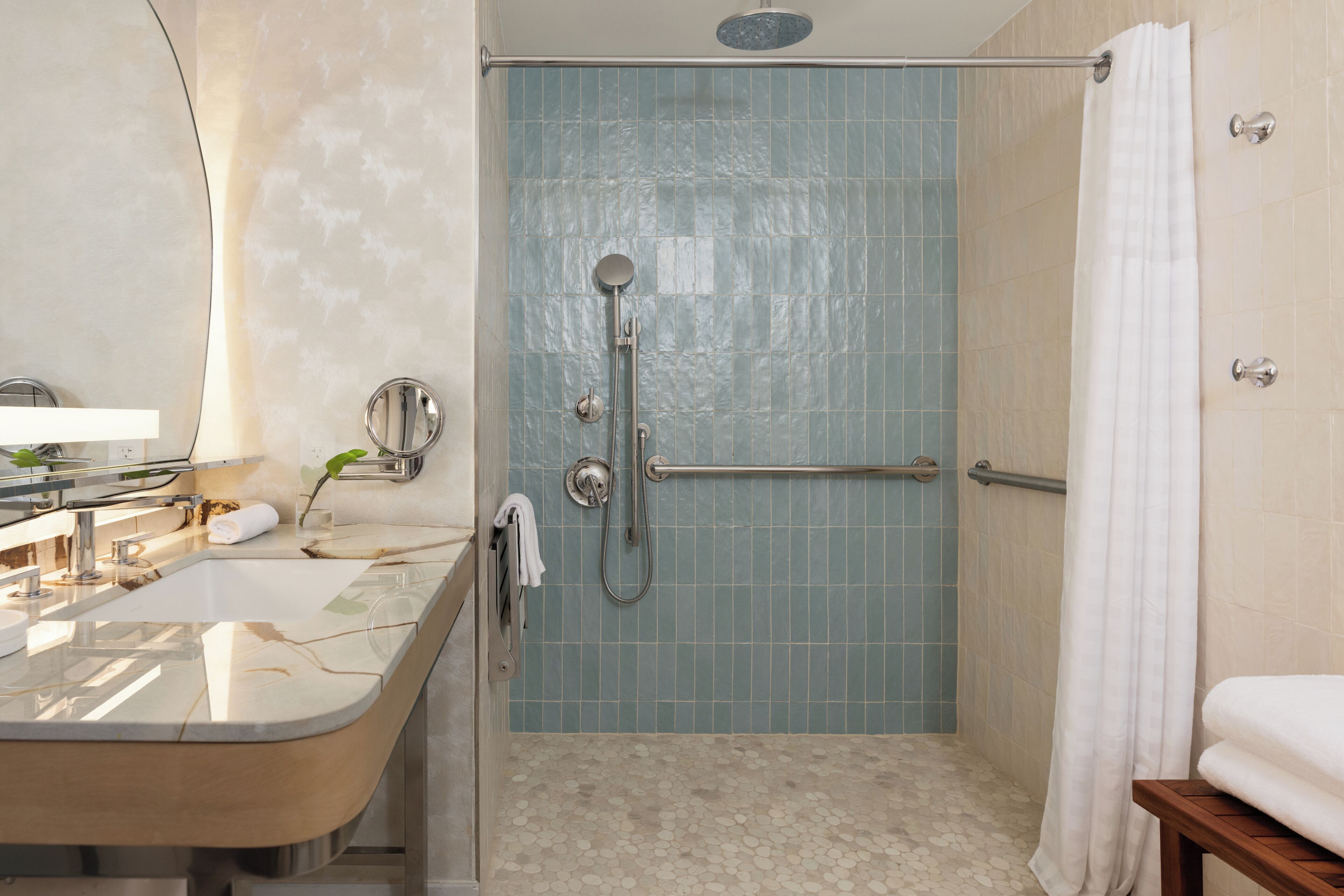 Ein Badezimmer mit einer Badewanne, einer Dusche, einem Waschtisch mit Spiegel und einem Handtuchhalter.