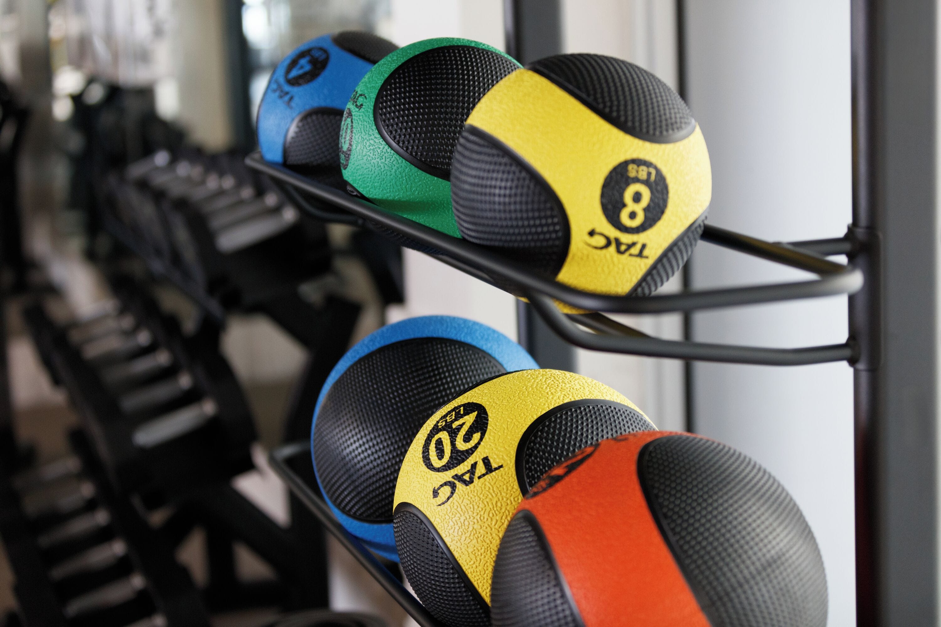 Een rek met medicijnballen in verschillende kleuren.