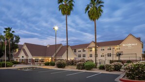 Ein Hotel mit Parkplatz, Palmen und einem Schild, auf dem "Residence Inn by Marriott" steht.