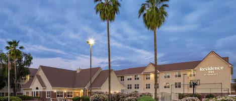 Ett hotell med en parkeringsplats, palmer och en skylt med texten ”Residence Inn by Marriott”.