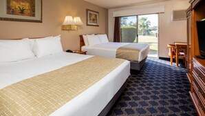 Una habitación de hotel con dos camas, un escritorio y una televisión.