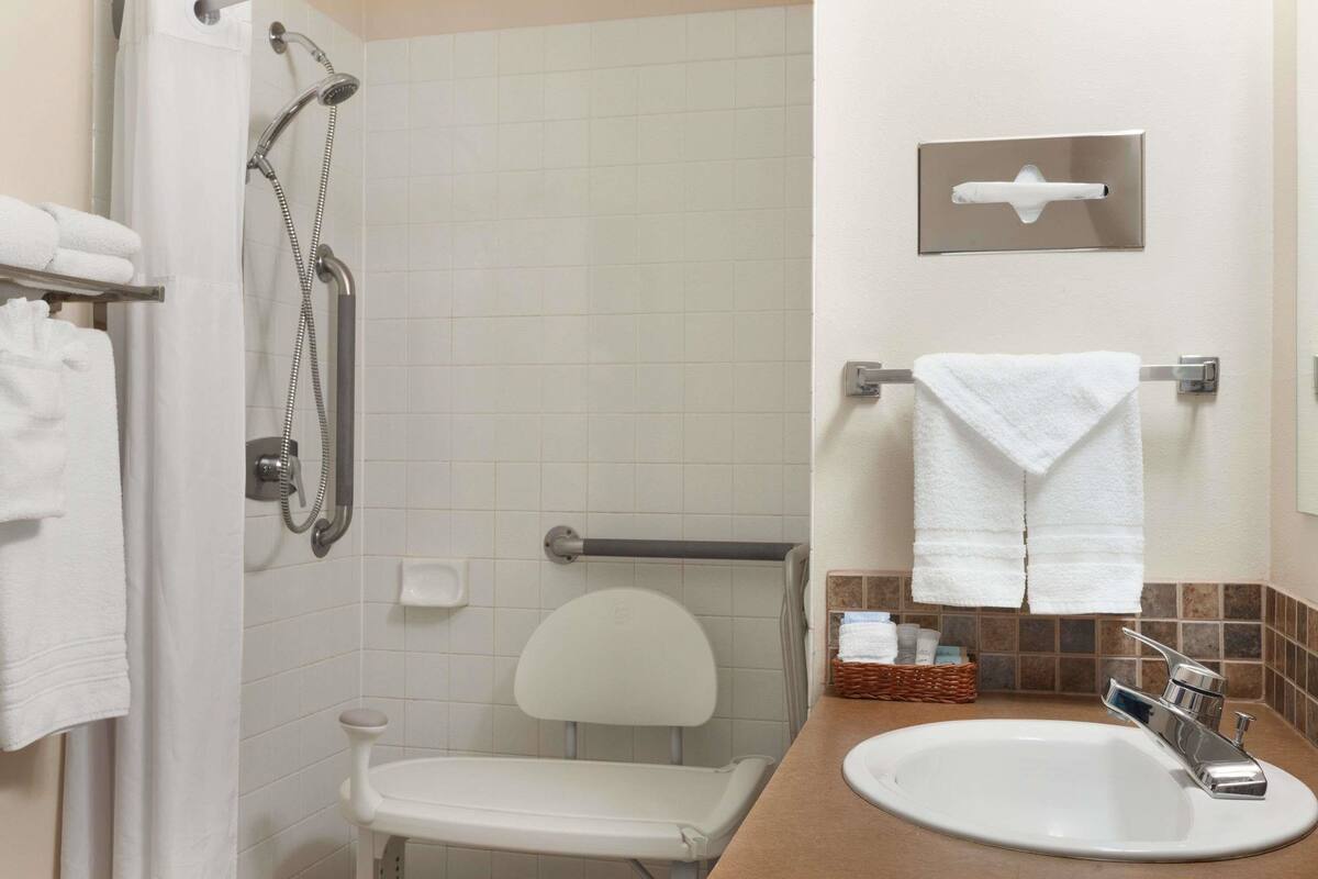 A bathroom with a shower, toilet, and sink.