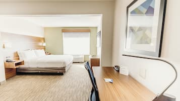 Una habitación de hotel moderna con cama, mesita de noche y escritorio con silla.