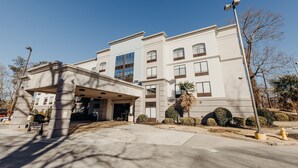 A multi-story hotel with a covered entrance, a palm tree, and a clear blue sky. - Holiday Inn Express Atlanta NE I-85 Clairmont by IHG (Atlanta)