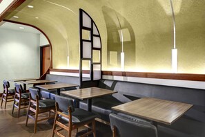 A restaurant interior with booth seating, wooden tables, and a curved ceiling. - Hyatt Place Boise/Towne Square (Boise)