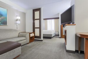 A hotel room with a sofa, a bed, a TV, and a large window with curtains. - Hyatt Place Fort Worth/Hurst (Hurst)
