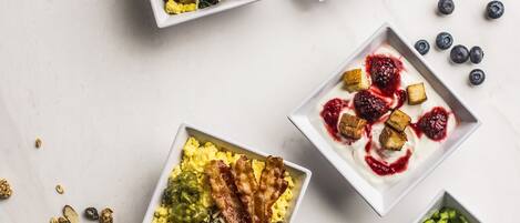A variety of breakfast dishes arranged on a marble surface.