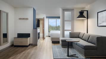 A modern interior with a sofa, a small table, a lamp, and a view through a window.