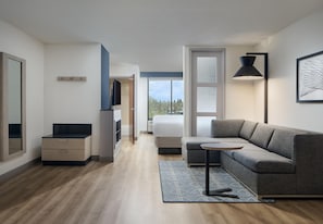 Un interior modern amb un sofà, una taula petita, una làmpada i una vista per la finestra.