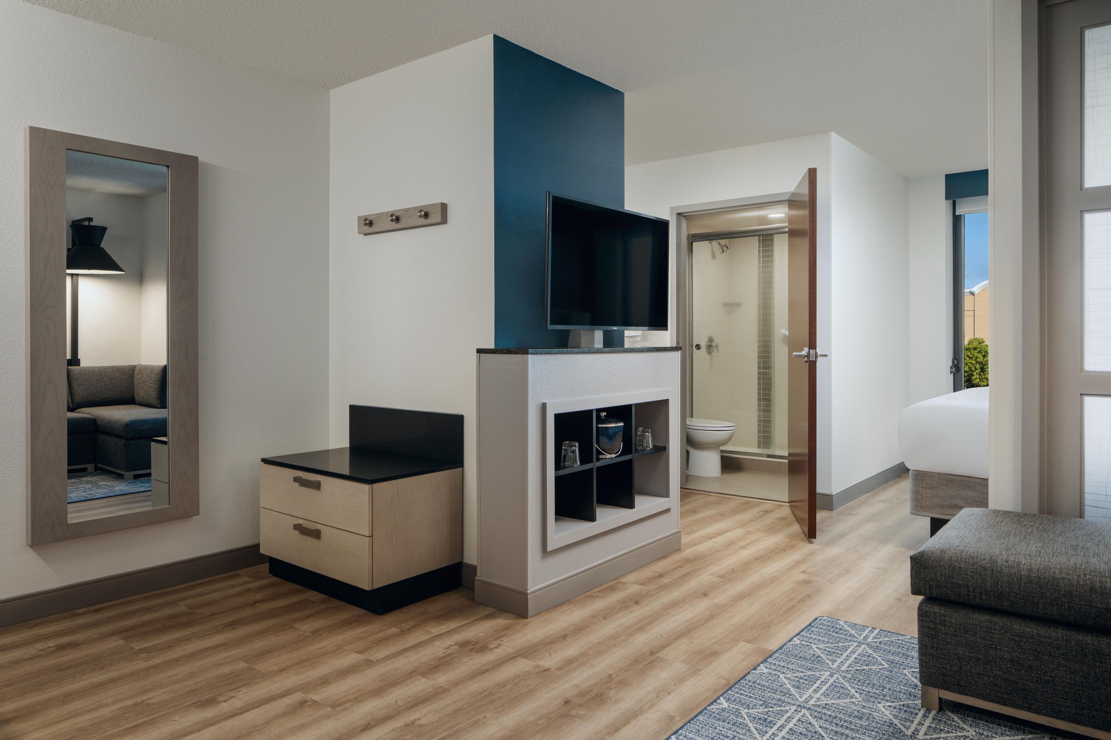 Una sala de estar moderna con un televisor de pantalla plana, un sofá, una mesa de centro y una estantería empotrada.