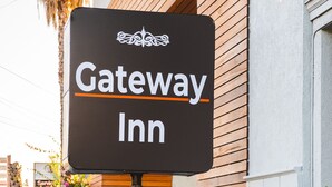 A sign for Gateway Inn with a modern building in the background. - Gateway Inn Gardena (Gardena)