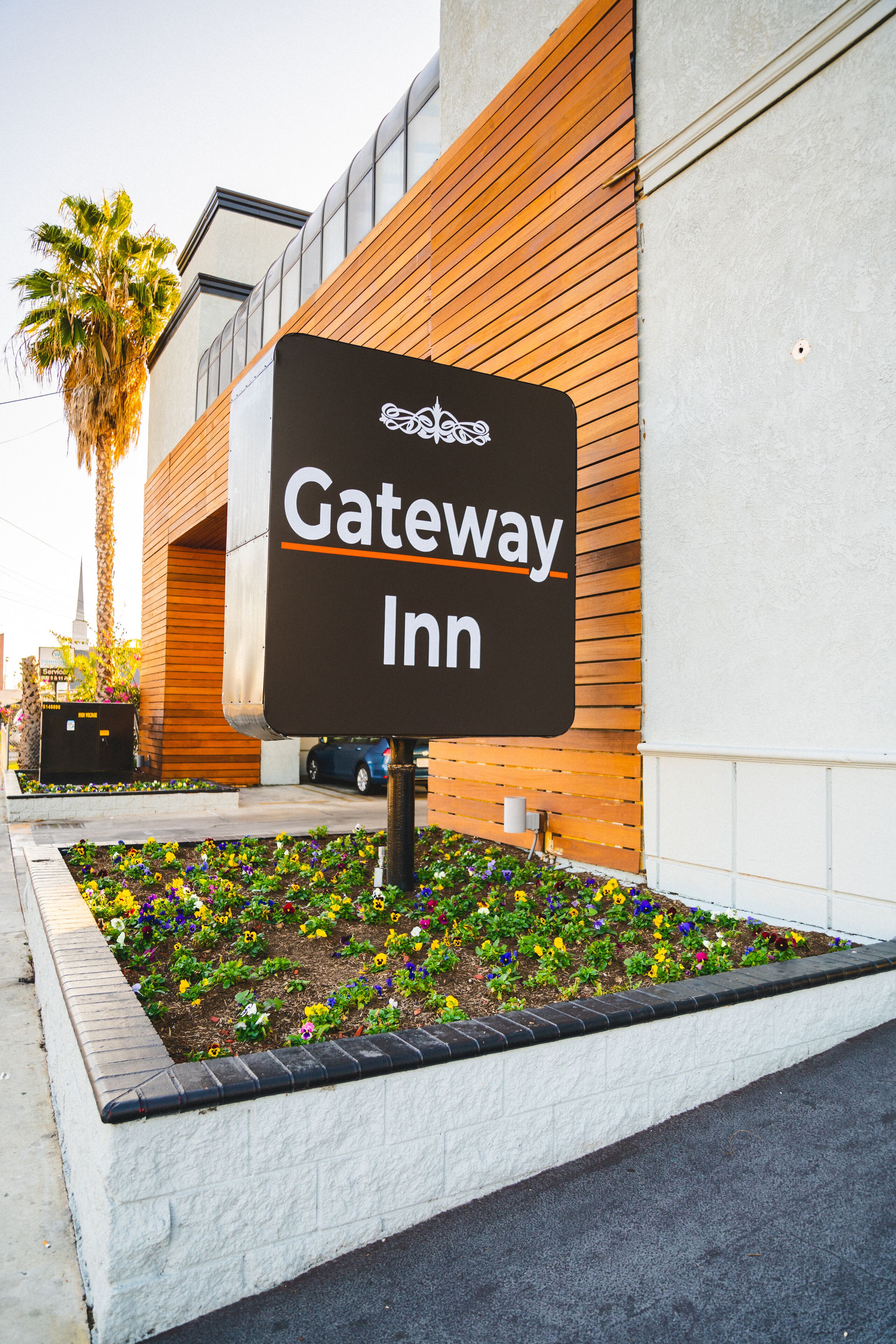A Gateway Inn sign with a modern building in the background.