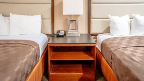 A hotel room with two beds, a nightstand with a lamp, and a phone. - Gateway Inn Gardena (Gardena)